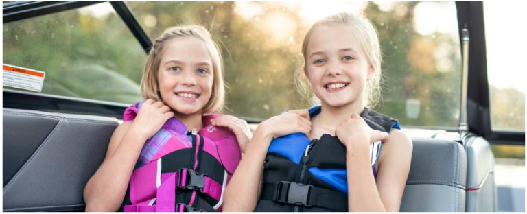 Young girls in lifejackets on boat