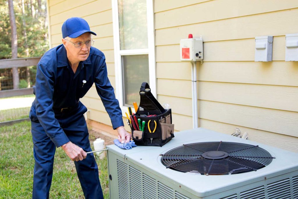 technician servicing an AC unit